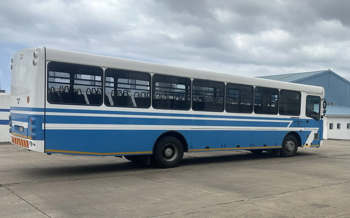 A blue and white bus parked at the depot on a cloudy day