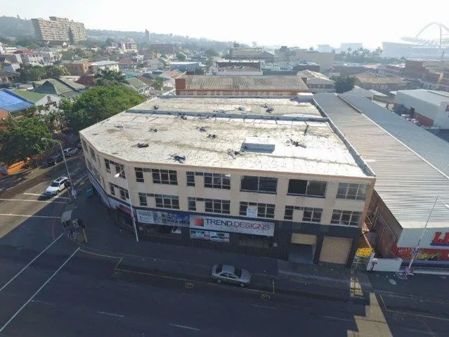 Aerial view of a corner commercial building with shops on the ground floor